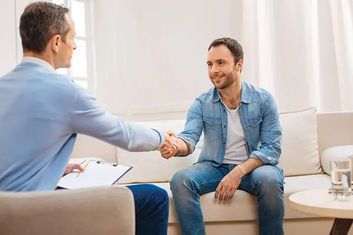 smiling man shaking hands with counsellor