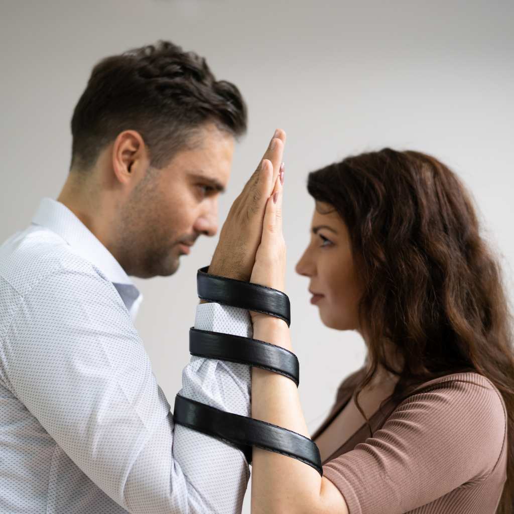 Pair facing each other with tied arms symbolizing codependency