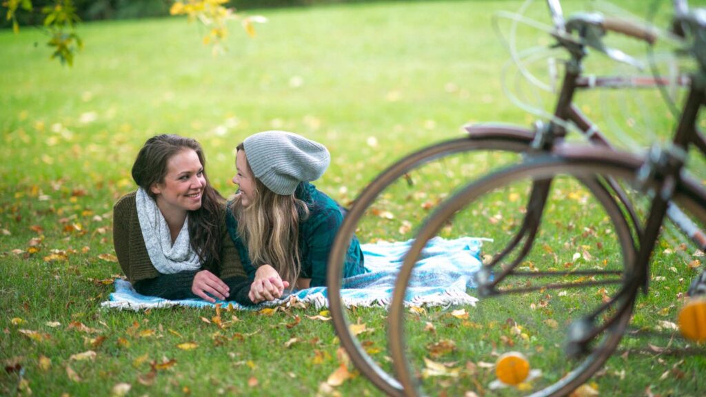 Two people enjoying a peaceful, alcohol‑free Valentine’s Day outdoors, lying on a blanket
