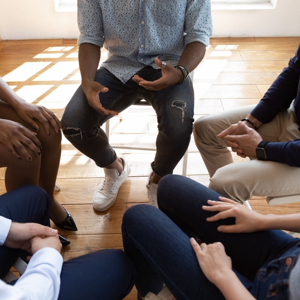 Adults participating in a group discussion about addiction and recovery